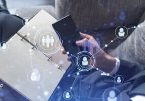 Hands of hr specialist browsing social networks in the Internet in smart phone to find the best candidates to hire international team. Concept of success. Media hologram icons. Formal wear.